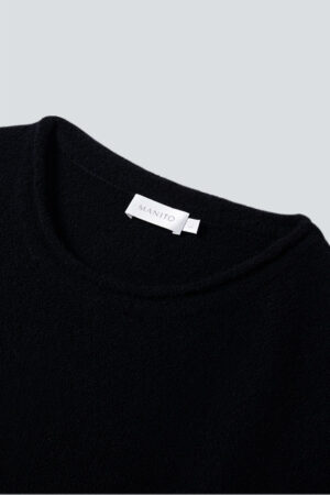 Close-up of MANITO Teddy black classy elastic knit lounge set neckline, showing soft knit texture and brand label.