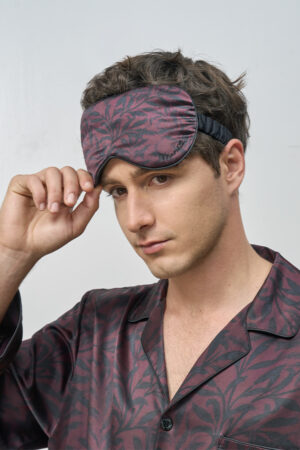 Model adjusts Tropical Leaves Men's Eye Mask, emphasizing elastic silk strap and detailed foliage pattern.