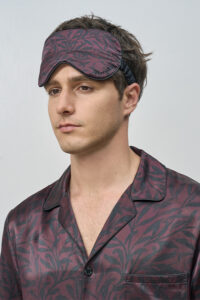Side view of model in Tropical Leaves Men's Eye Mask, showing smooth silk texture that enhances restful comfort.