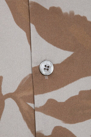 Close-up of MANITO Tropical Men's Short Pajama Set shell button with engraved logo.