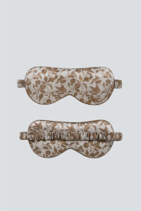 Overview of MANITO Tropical Silk Eye Mask in light taupe color, the top showing the floral design front and the bottom.