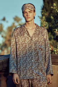Man wearing the MANITO Tropical Silk Eye Mask in light taupe color atop his head.