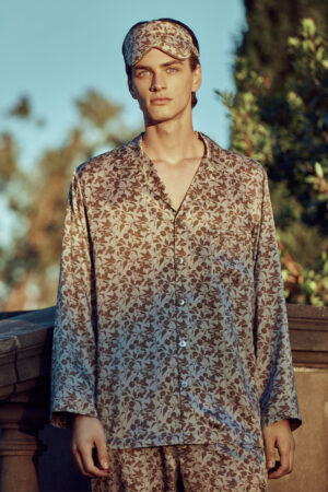 Man wearing the MANITO Tropical Silk Eye Mask in light taupe color atop his head.