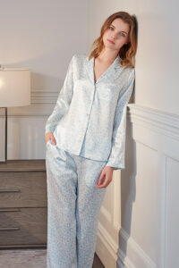 Woman in a Gentle Leo Silk Pajama Set with a chic leopard print design, offering a blend of style and comfort for loungewear.