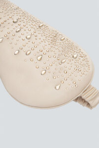 Close-up of champagne gold MANITO Twinkle Silk Eye Mask decorated with delicate crystal patterns.