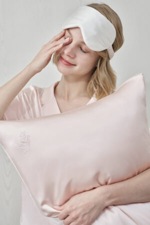 Woman gently rubbing her eyes while wearing MANITO Wedding Mr. & Mrs. Silk Eye Mask.