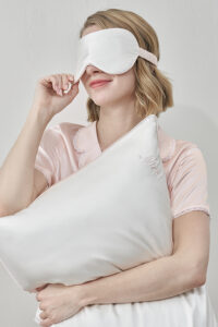 Woman smiling while adjusting MANITO Wedding Mr. & Mrs. Silk Eye Mask.