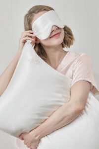 Relaxed woman wearing MANITO Wedding Mr. & Mrs. Silk Eye Mask.