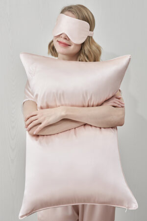 Woman hugging pillow from MANITO Wedding Mr. & Mrs. Silk Pillowcases Gift Box, a soft pink pillow for couples.