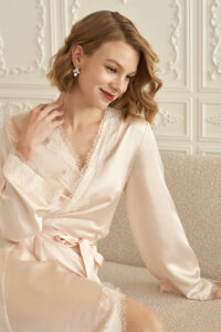 Model smiling in MANITO Wedding Women's Lace Silk Short Robe, showing soft pink tone.