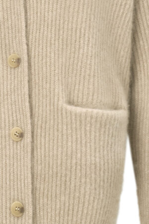 Detail of Wunder Cardigan pocket under soft light, revealing delicate knitting and cozy craftsmanship.