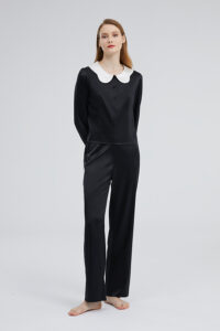 Full body view of a woman dressed in the black Doll Silk Loungewear Set, showcasing a seamless blend of luxury and casual style.