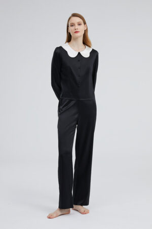 Full body view of a woman dressed in the black Doll Silk Loungewear Set, showcasing a seamless blend of luxury and casual style.