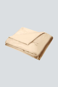 Folded champagne Silk Throw Blanket with elegant satin sheen and tie closure.