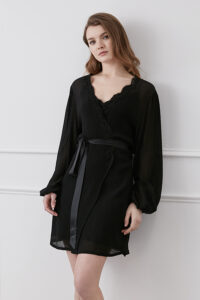 Elegant woman showcasing a black Latica Lace-trimmed Silk Robe with delicate lace details and a satin tie.