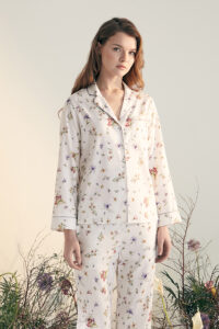 Woman wearing Lrisette Silk Pajama Set with Delicate Floral Print, embodying chic and comfort.
