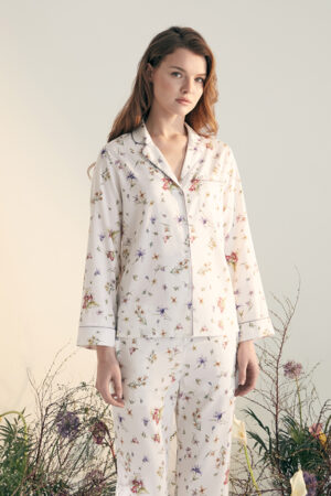 Woman wearing Lrisette Silk Pajama Set with Delicate Floral Print, embodying chic and comfort.