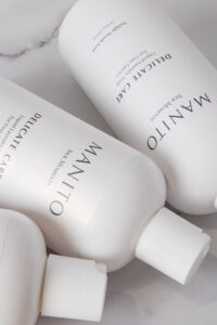 Close-up of MANITO Delicate Care Delicate Laundry Liquid Soap bottles highlighting texture and label details.