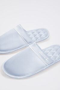 Close view of blue Authentic Women's Silk Lounge Shoes, highlighting silk upper with neat piping and diamond-quilt footbed.