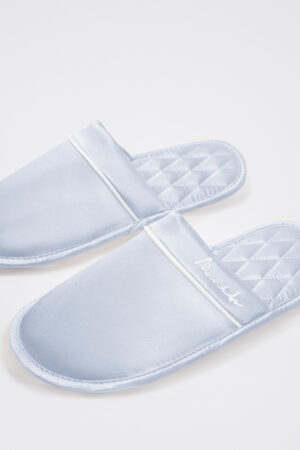 Close view of blue Authentic Women's Silk Lounge Shoes, highlighting silk upper with neat piping and diamond-quilt footbed.