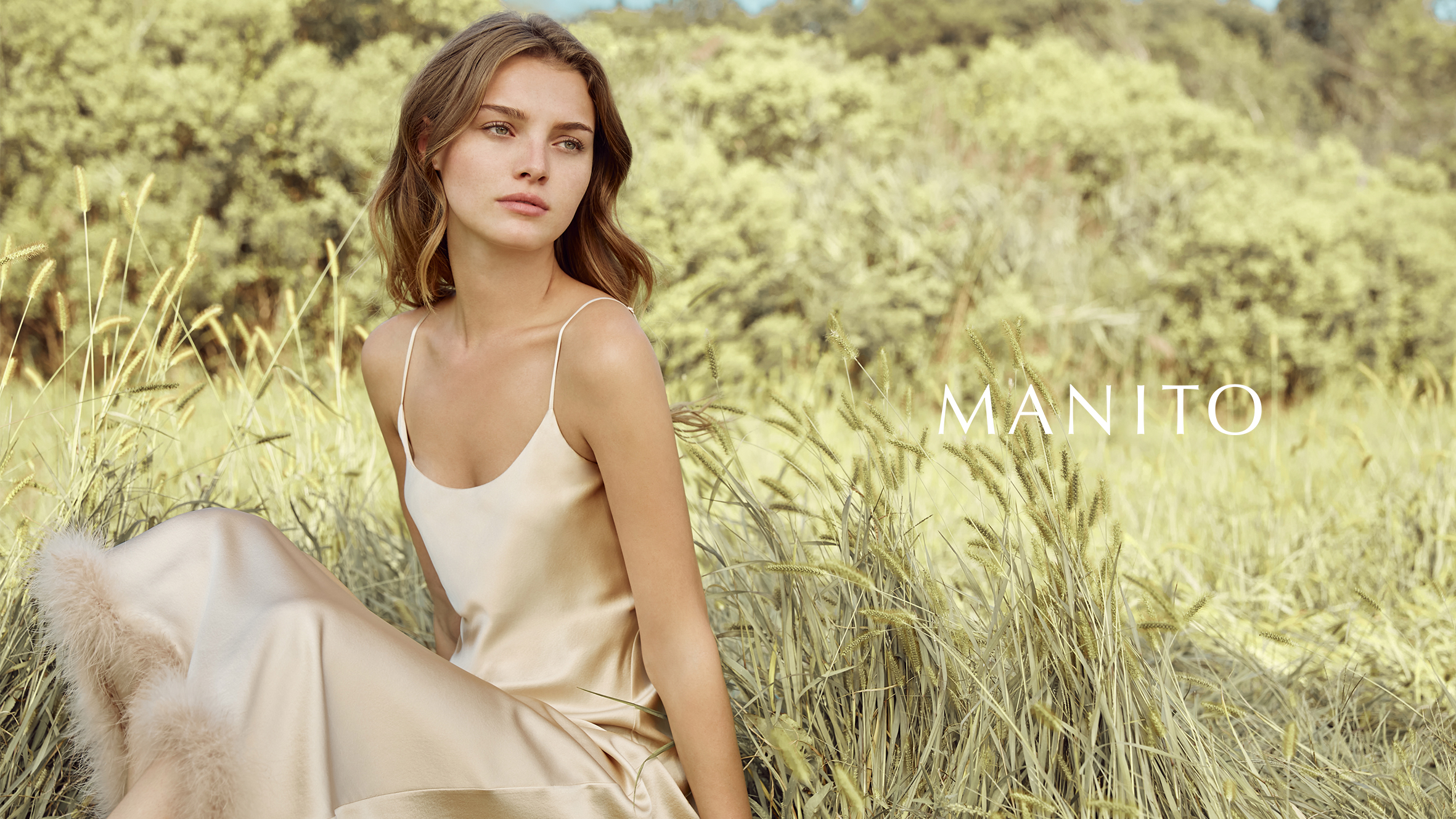 Elegant woman in a beige silk slip dress in a natural outdoor setting, embodying how to style a slip dress with simplicity and grace.