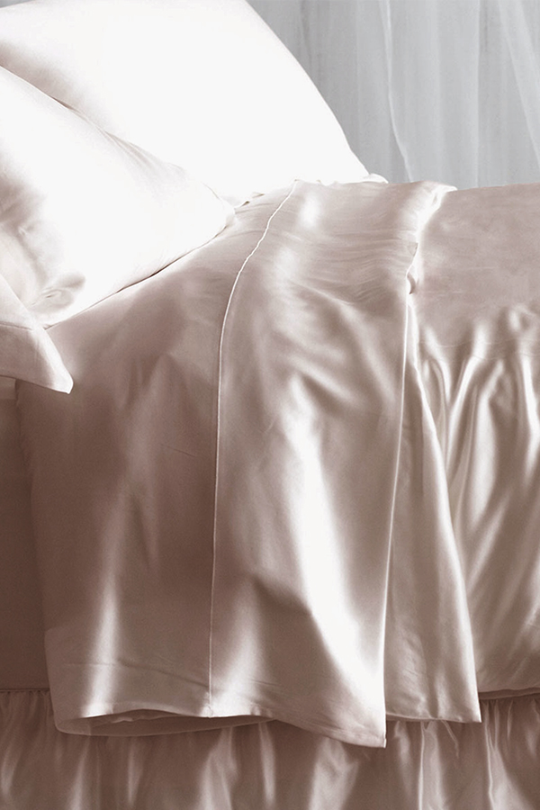 Elegant 22 silk duvet cover in soft pink, draped gracefully on a bed, embodying sophistication and comfort.