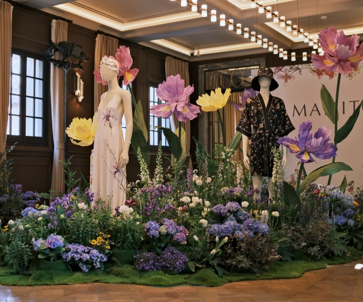 MANITO's fashion display with mannequins adorned in the SS 2023 silk collection, amidst an opulent floral arrangement, capturing the essence of Butchart Gardens' blooming irises.