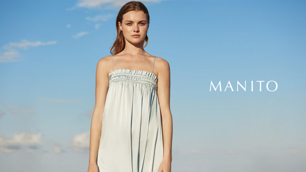 Fashion-forward styling tips for a silk slip dress showcased by a woman against a sky backdrop, capturing the essence of how to style a slip dress.