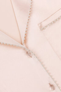 Close-up of the Treasure Short Pajama Set in peach, showcasing the exquisite trim and button details.