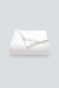Luxurious silk filled duvet in ivory color providing comfort and elegance for the bedroom decor.