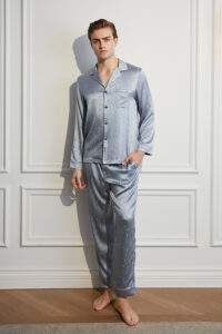 Model in silver MANITO Fragment Men's Pajama Set with long-sleeve silk shirt and relaxed pants.