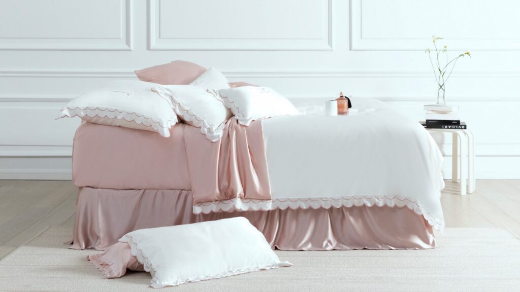 Luxury pink and white silk bedding with scalloped edges