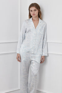 Woman posing in a Script Women's Blue Silk Pajama Set, featuring a distinctive script pattern for a chic sleepwear choice.