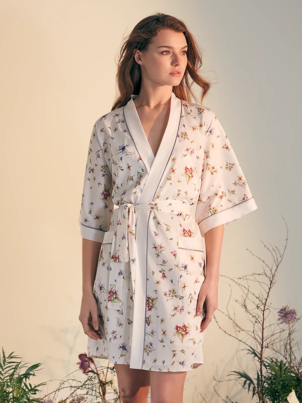 Model in MANITO floral silk robe with a belted waist, captured in soft natural light.