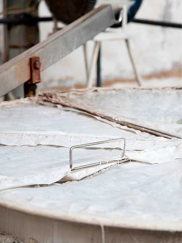 Traditional silk-making tools on silk fabric, highlighting MANITO's craftsmanship.