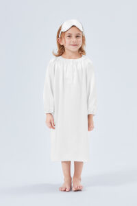 The little girl is wearing a white silk nightgown and a silk eye mask in matching colors.