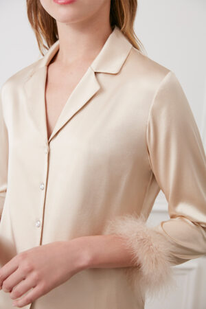 Close-up of champagne MANITO Diva Pajama top with feather-trimmed cuffs and crystal buttons.