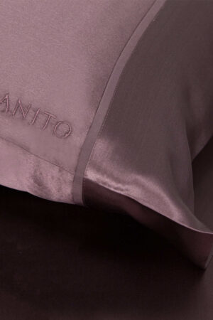 Close-up of The 22 Silk Pillowcase Set in plum purple color with embroidered logo of MANITO.
