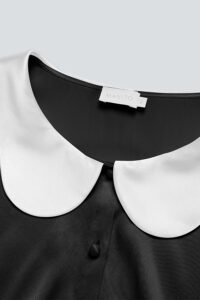 Detail of the neckline of the Doll Silk Loungewear Set showing the MANITO logo.