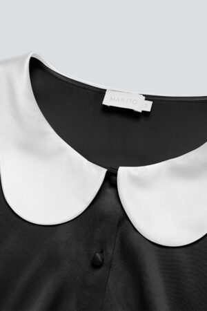 Detail of the neckline of the Doll Silk Loungewear Set showing the MANITO logo.