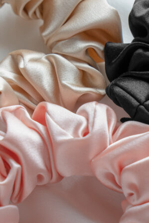 Close-up of 3 Pack Large Silk Scrunchie Set in pink, champagne and black, showing lustrous silk texture.