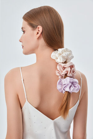 A lady shows off her elegance wearing three different colors of Twinkle Silk Scrunchie. Adorned with imported crystals, they look like they are dotted with stars.