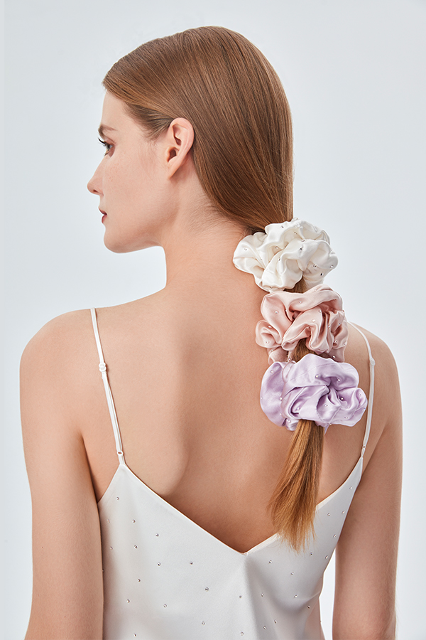 A lady shows off her elegance wearing three different colors of Twinkle Silk Scrunchie. Adorned with imported crystals, they look like they are dotted with stars.
