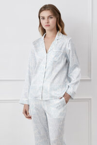 Woman in blue Script Silk Pajama Set for women with a subtle brand print, posing for a relaxed yet elegant look.