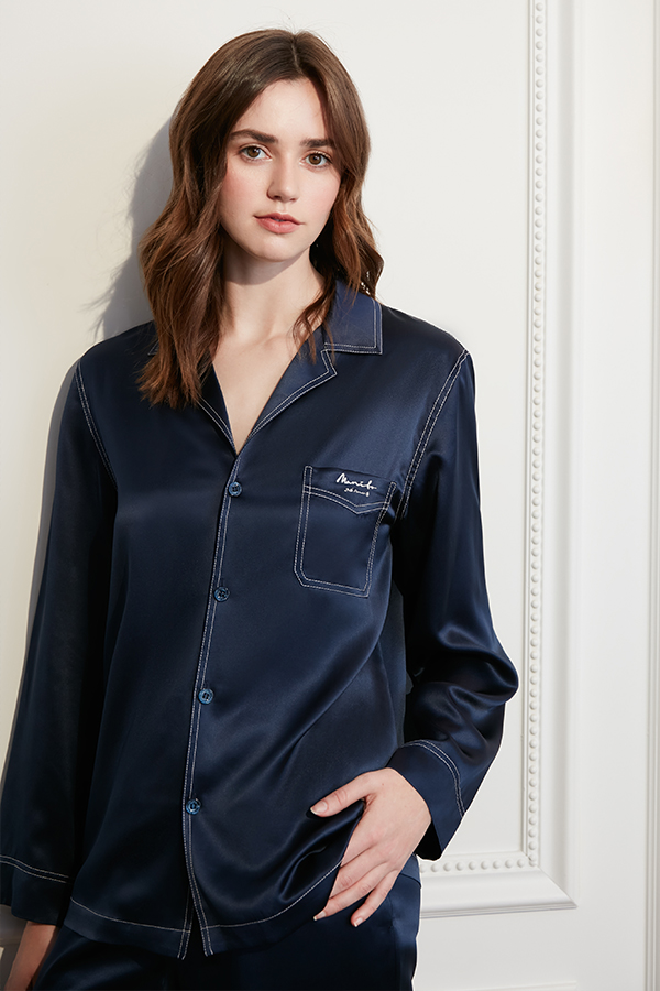 Woman in Liberty Silk Pajama Set featuring pastel hues with a classic design, exuding comfort and style.