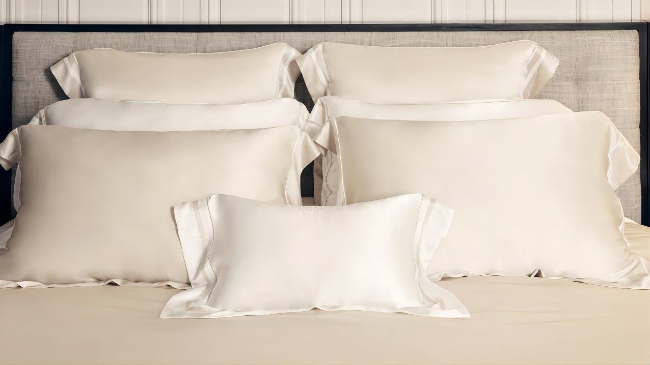 An arrangement of silk pillowcases on a bed, emphasizing the query how often to wash your silk pillowcases to maintain their quality.