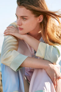 Side view of woman in MANITO Macaron Silk Pajama Set, relaxed fit with soft color contrast.