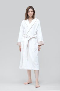 Woman wearing Brimmy Silk Terry Women’s Robe with elegant pink trim detailing.