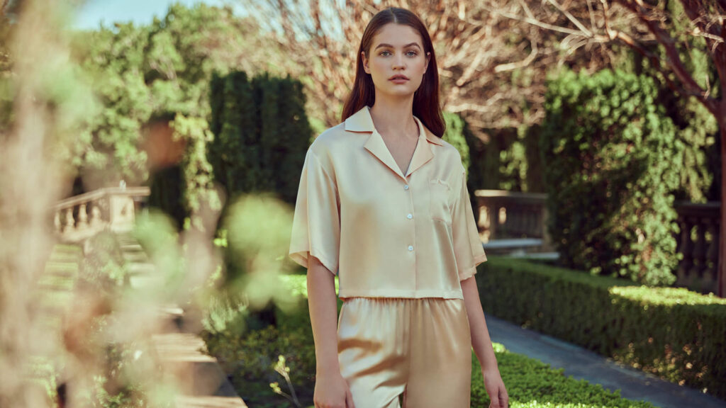 Woman in luxurious silk pajamas standing in a garden