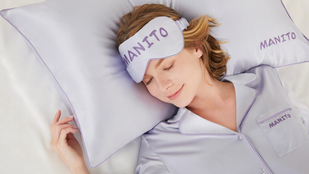 Woman sleeping peacefully on a luxurious flat sheet.